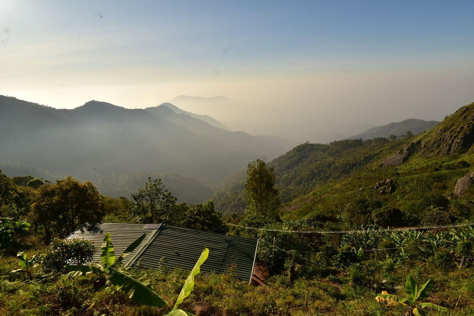 Panoramic view of lush valley and layered mountain peaks from Shanti Earth’s hilltop