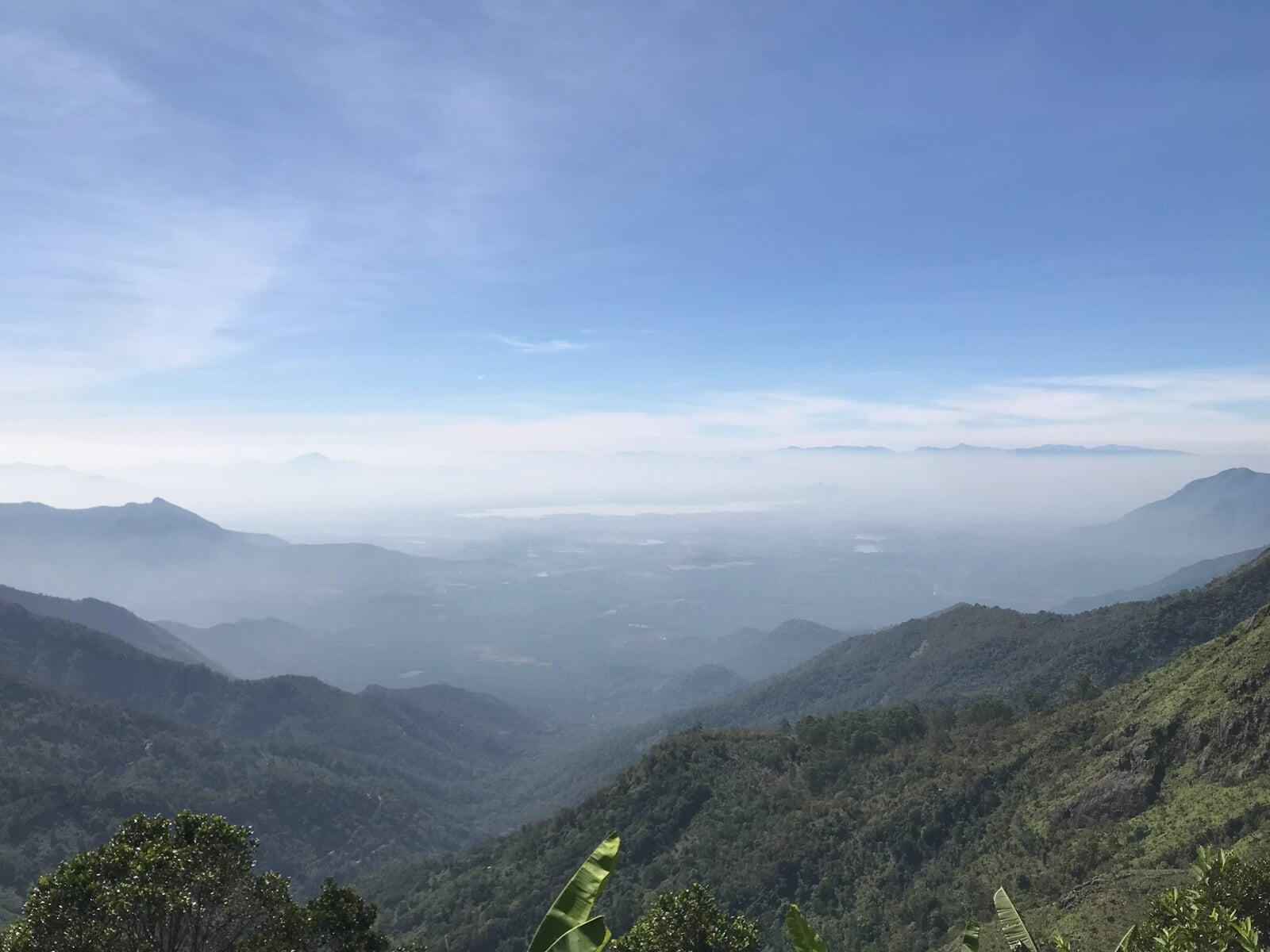 Expansive green valley surrounded by forested hills, as viewed from Shanti Earth’s high vantage point